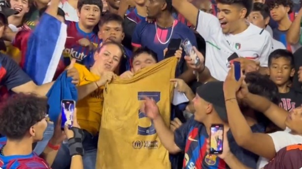 皮克赛后到场边与球迷互动，并将球衣送给巴萨小球迷