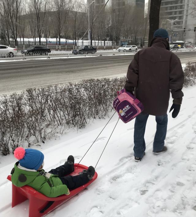 烟台暴雪后家长拉滑雪板接送小孩